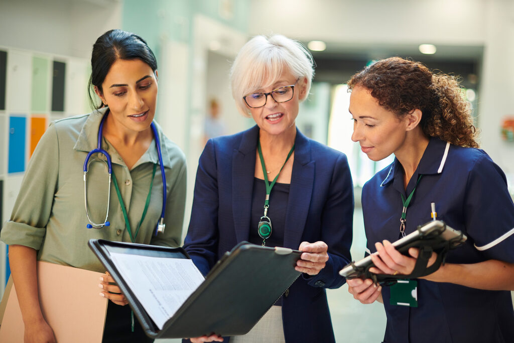 Three female presenting nurses working in a hospital setting
